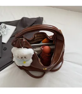 Vue détaillée du grand sac cabas marron foncé montrant la doublure rayée et le rangement