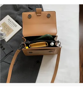 Vista dall'alto di una borsa a tracolla marrone con interno spazioso e diversi scomparti