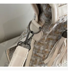 Makro-Detail des mehrfarbigen Tweed-Stoffs und Elfenbeinlederbesatz mit Metallbeschlägen