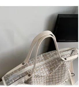 Detail der Tweed-Tasche mit Silbernieten an weißen Kunstledergriffen und Reißverschluss