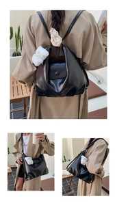 Détail d'un sac en cuir noir brillant avec un lapin en peluche et un ruban en dentelle