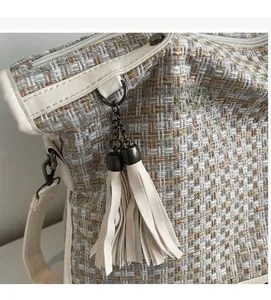 Nahaufnahme der beigen Tweed-Tasche mit PU-Lederbesatz und Metallketten-Quaste