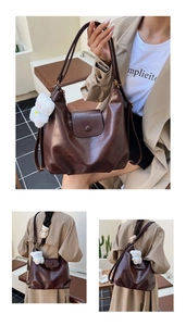 Grand sac fourre-tout vintage marron avec breloque ours, porté par un mannequin en manteau