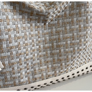 Detailansicht der gewebten Tweed-Tasche mit Lederbesatz und goldenen Nietendetails