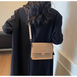Dettaglio borsa a tracolla kaki con scritta Fashion & Bags e cinturino regolabile