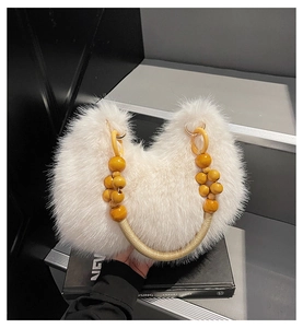 Detail of white faux fur moon bag with wooden bead handle and braided rope strap