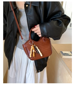 Close-up of woven bucket bag texture with decorative wooden beads and leather strap