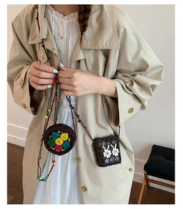 Détail montrant deux mini sacs bandoulière tissés à la main au style bohème avec fleurs et cœurs