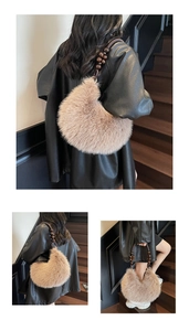 Detail of plush crescent moon bag featuring brown wooden bead handle and furry texture