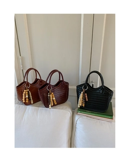 Detail of woven bucket bags in brown, dark red and black with beaded tassel charms