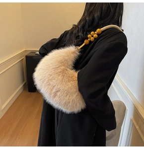 Detail of plush moon bag featuring yellow beaded strap and soft faux fur texture