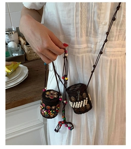 Detail of bohemian handmade woven mini crossbody bags with colorful beads and wood accents