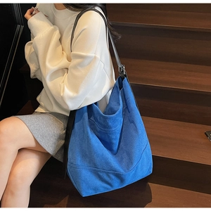 Détail du grand sac cabas bleu en daim avec bandoulière en cuir noir et boucle en métal