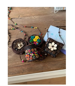 Gros plan de sacs bohèmes artisanaux en noix de coco avec perles et fleurs colorées