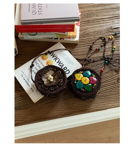 Détail de mini sacs bohèmes en coque de noix de coco tressée avec fleurs et perles