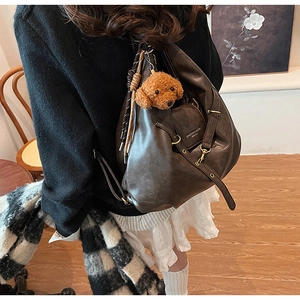 Detail view of coffee brown tote bag with adjustable strap and teddy dog plush charm