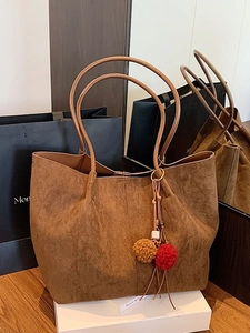 Brown suede tote bag with fringe charm and long handles for daily commuting and shopping