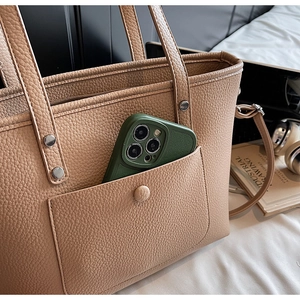 Braune Leder-Einkaufstasche mit Handytasche, präsentiert mit Lifestyle-Zubehör im Detail