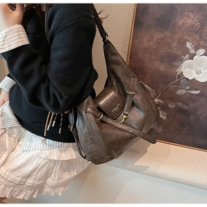 Detail of a brown vintage hobo bag with gold ring buckles and embossed brand logo