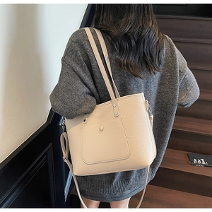 Detailansicht der cremefarbenen Tragetasche aus Leder mit Litschistruktur und Vordertasche
