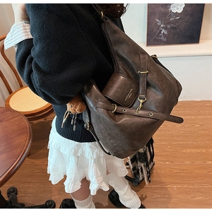 Detail view of coffee brown vintage tote bag with gold hardware and retro leather texture