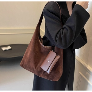 Detail of dark brown suede tote bag featuring a matching small zip pouch and soft texture