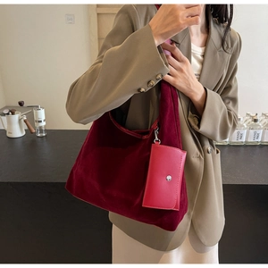 Detail of burgundy velvet tote bag with matching pendant wallet in cafe setting
