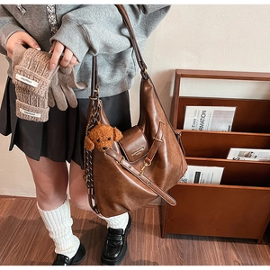 Brown vintage faux leather tote bag with plush bear charm and matching knit gloves