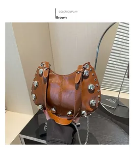 Detail of brown semi-circular handbag featuring large silver rivets and metal chain strap