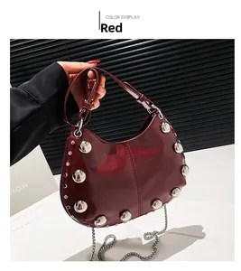 Detail view of burgundy leather saddle bag with silver rivets and metal chain strap