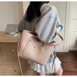 Seitenansicht der beigen Tote Bag mit Litschimuster als Umhängetasche am Model