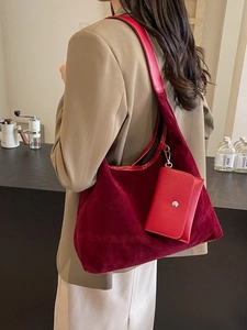 Minimalist burgundy suede tote bag with inner pouch shown in a modern cafe setting