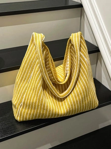 Knitted tote bag with yellow and white stripes featuring soft crochet texture and wide strap