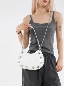 White crescent hobo bag with silver studs and chain strap shown on a model