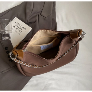 Detail of internal zipper pocket and branding on brown nylon shoulder tote bag