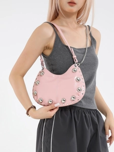 Pink retro hobo bag with silver studs and double straps shown on model in studio