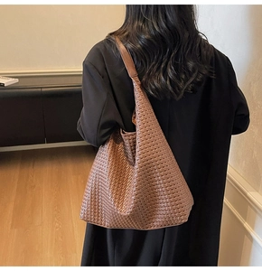 Detail of a brown woven leather hobo bag showing texture and casual shoulder drape