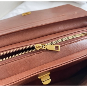 Detailed close-up of premium brown leather tote bag interior with gold metal zipper