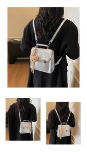 Close-up of shiny silver sequin backpack with plush bear pendant and fashion lettering