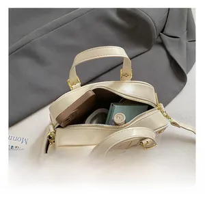 Interior view of off-white leather pillow bag showing space for phone and makeup