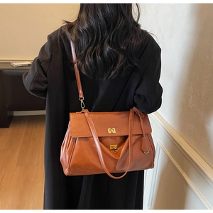 Detailed back view of a caramel brown leather tote bag showing size and texture on model