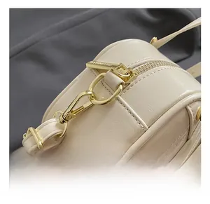 Detail of high-quality gold metal hooks and soft cream leather texture on the bag