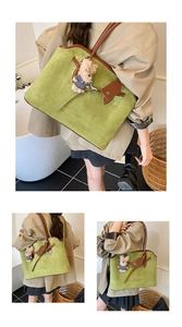 Detail van groene faux suède shopper met bruine leren hengsels en een schattige beer