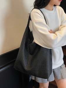Classic black woven tote bag made of faux leather with wide shoulder strap for women