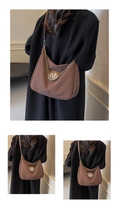 Detailed view of a brown hobo shoulder bag with chain detail and metallic M logo