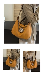 Detail of ginger yellow suede tote bag with metal M logo and thick decorative chain