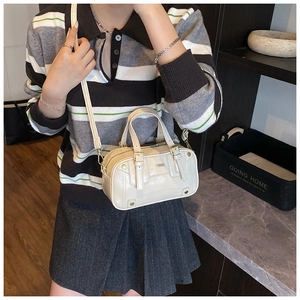 Detail of off-white mini Boston bag featuring metallic hardware and crossbody strap