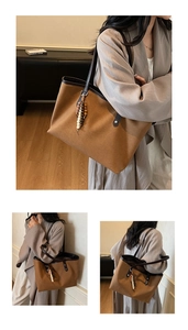 Detail of tan canvas tote bag with brown leather straps and wooden bead tassel charm