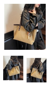 Detail of khaki canvas tote bag with brown leather straps and beaded tassel charm