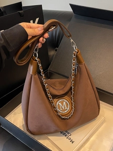 Dark brown suede hobo bag with silver M logo and chain strap for stylish daily commuting